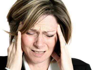 Woman with a bad migraine headache holding her head.